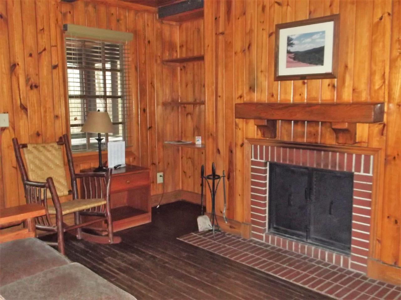 A view of the living room area in cabin 12 a couch, rocking chair and fireplace